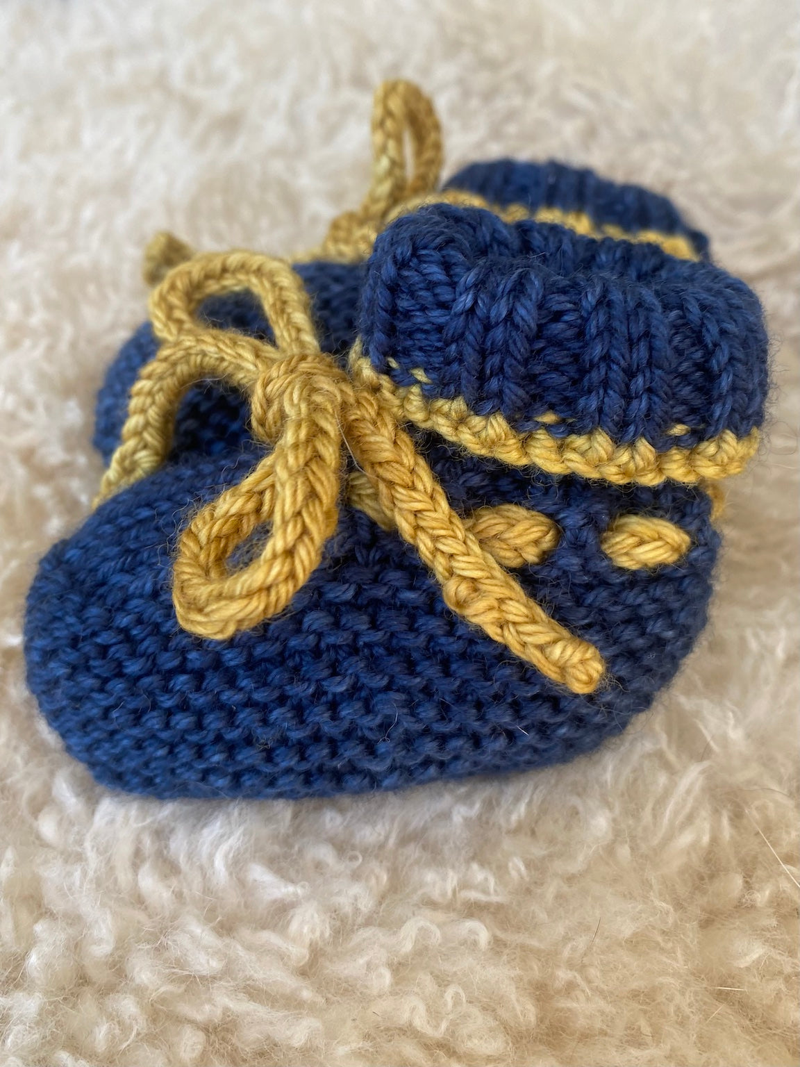 details of baby booties in blue merino wool