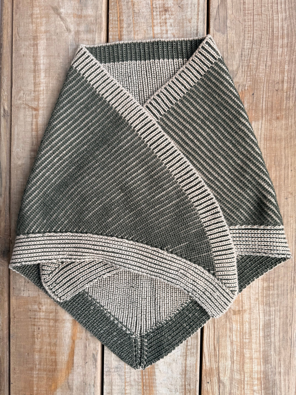 brioche knit scarf in sand and moss green on wooden surface