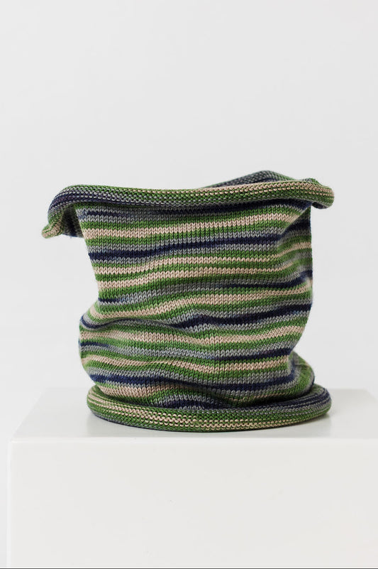 Knitted wool neck warmer with green and blue pattern on a white background
