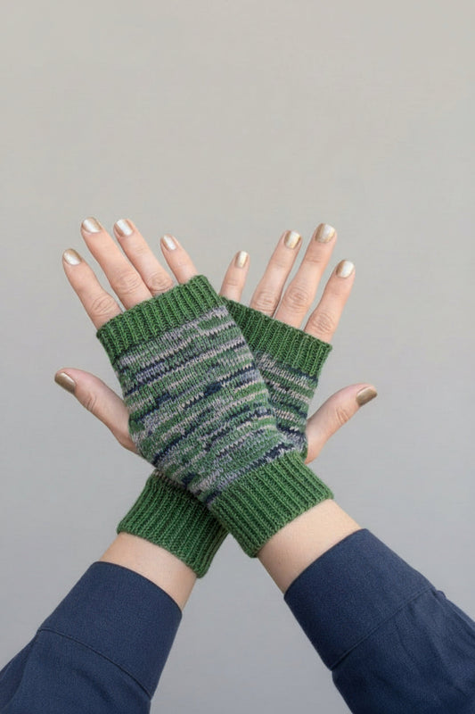 Green striped  knitted fingerless gloves worn on a gray background